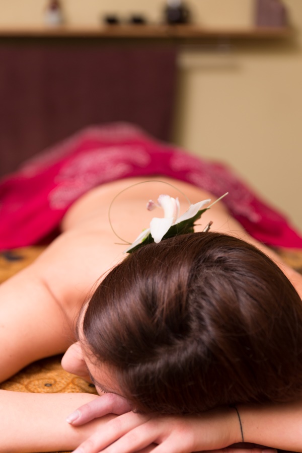 Femme avec orchidée allongée pour recevoir son massage balinais – Le Monde Sensible Montpellier